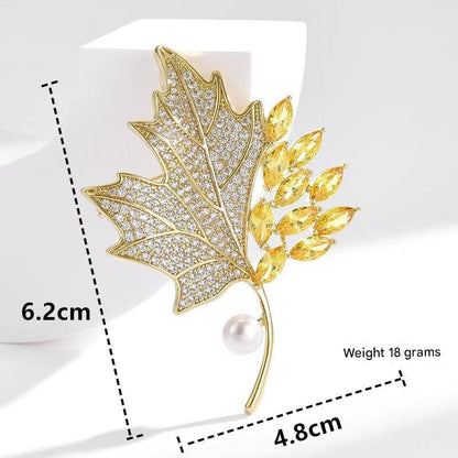Golden maple leaf brooch with pearl accent