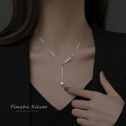 Close-up of pearl detailing on silver necklace